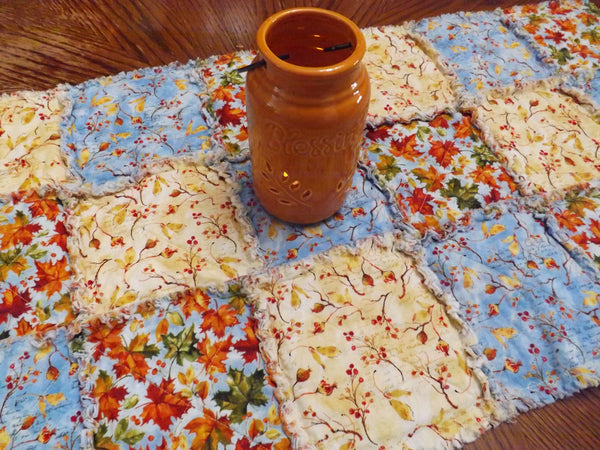 Autumn blue rag quilt table runner on dining room table with candle 