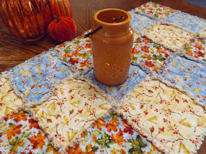Autumn blue rag quilt table runner on dining room table with candle and pumpkins