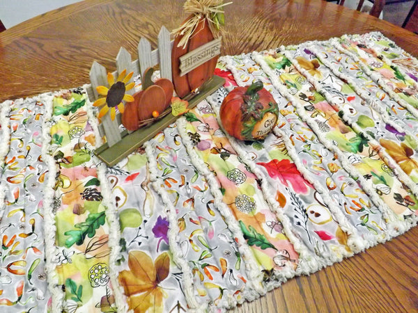 Acorns and autumn leaves rag quilt table runner with bright autumn colors on dining room table